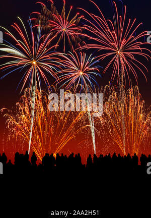 Silhouette of people at a firework display. Stock Photo