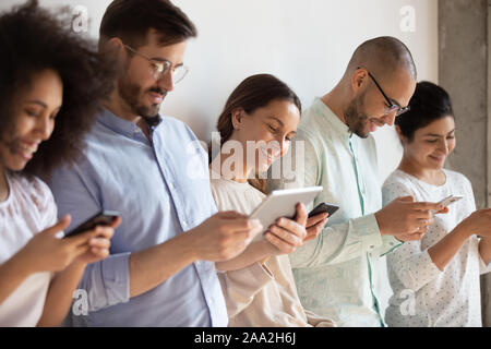 Addicted to technology group of mixed race students using devices. Stock Photo