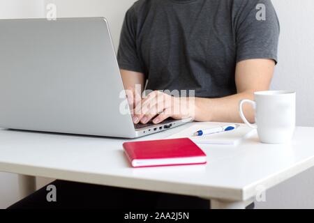 Midsection of young man using laptop Stock Photo
