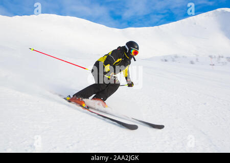 Professional athlete skier training the race of super g skiing downhill on slope in winter mountains on sunny day Stock Photo