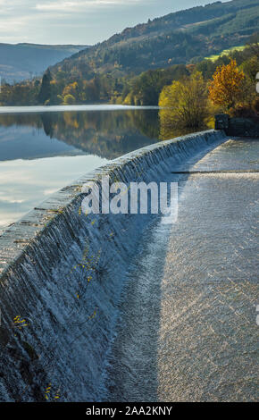 The overflow weir at Talybont reservoir in the Brecon Beacons National Park Powys south Wales with the reservoir and autumnal trees on the background. Stock Photo