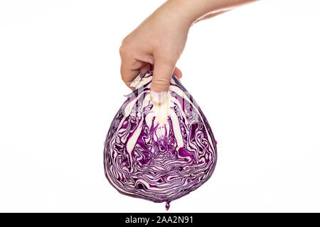 A hand holding a red cabbage. White background. Half a cabbage. Fresh vegetables. Salad products. Healthy food. Vegan cuisine. Stock Photo