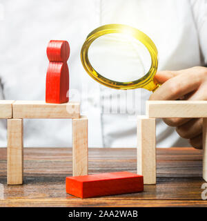 A businessman is studying a problem and ways to solve it. Wrong business model, unprofitability and inefficiency. Failed project. Testing. Risk manage Stock Photo