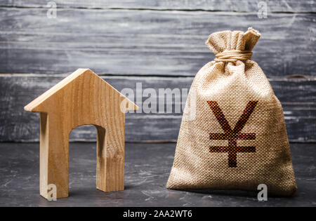 Yen yuan symbol money bag and house. Real estate purchase and investment. Affordable cheap loan, mortgage. Taxes, rental income. rent or buy. Home bud Stock Photo