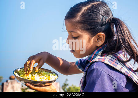 Sijhora,Madhya pradesh,India-November 19, 2019 :Close up portrait cute Indian school girl are eating food. at India Stock Photo