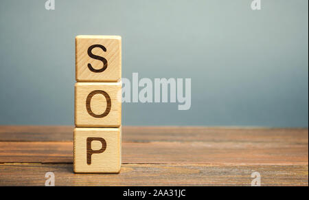 Wooden blocks with the word SOP ( Standard operating procedure ). Instructions to assist employees in complex routine operations. Business concept Stock Photo
