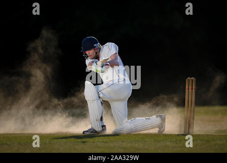 Cricket batsman Simon Hasted playing sweep shot on dry, dusty wicket - Dorset - England. Model released for commercial use and editorial use. Stock Photo