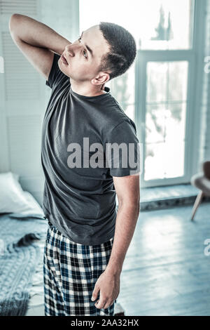 Good looking young man feeling pain in the neck Stock Photo