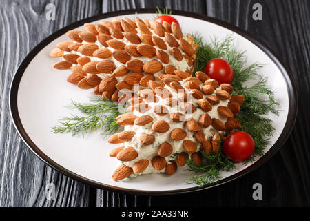 Festive salad with almonds in the form of pine cones close-up on a plate on the table. Beautiful menu. horizontal Stock Photo