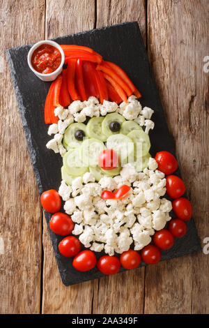 Diet Christmas appetizer in the shape of Santa Claus close-up on the table. Beautiful presentation. Vertical top view from above Stock Photo