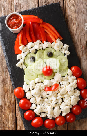 Fresh vegetables in the shape of Santa Claus. Idea for Christmas food close-up on the table. Vertical top view from above Stock Photo