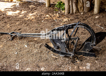 Old iron black farm plow on the dry grass in Israel's northern city of Rosh Pina Stock Photo