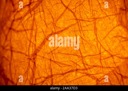 Abstract illuminated orange background from paper on an old lantern in a restaurant Stock Photo