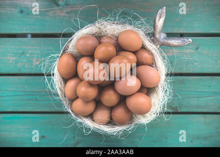 Easter eggs in a silver bowl standing ouside on a green bench, silver basket, rabbit, bunny head, easter decoration, luxury, postcard, wallpaper, sree Stock Photo