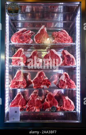 Close-up of a display fridge with raw meat cuts used to cook Florentine steaks, a typical Tuscan dish, Florence, Tuscany, Italy Stock Photo