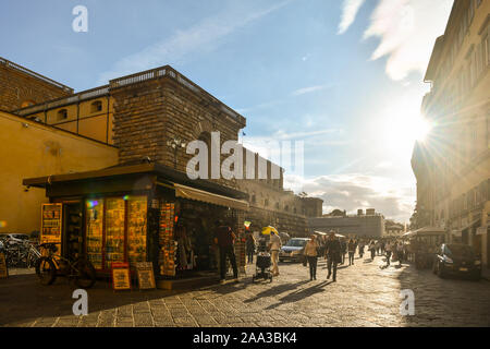 Backlight view of the historic centre of Florence, Unesco World Heritage Site, with a newsstand in front of Palazzo Pitti museum, Tuscany, Italy Stock Photo