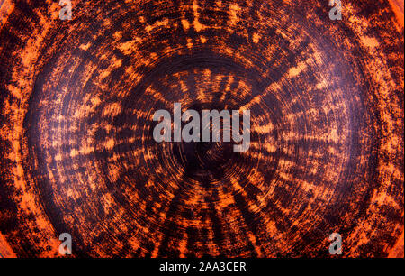 Abstract background with natural clay plate spiral detailed texture and pattern. Ecology friendly material colored in blend of bright neon orange, bro Stock Photo