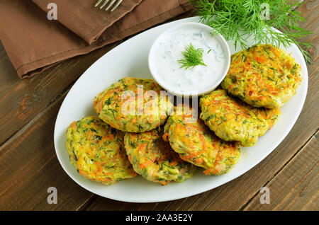Vegetable cutlet from zucchini, carrot, herbs on wooden table Stock Photo
