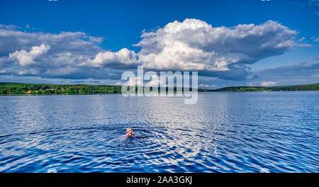 Swedish woman taking a swim alone in a lake Stock Photo
