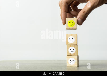 Conceptual the customer responded to the survey. The Businessman hand choose happy face smile icon on top. Depicts that customer is very satisfied. Se Stock Photo