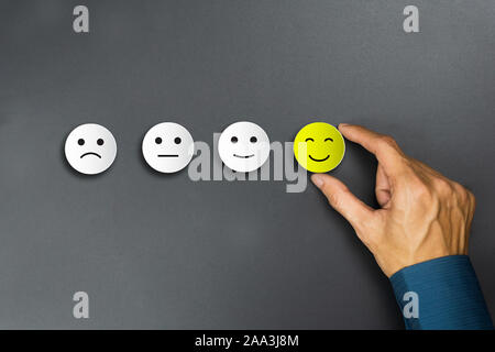 Conceptual the customer responded to the survey. The client using hand choose happy face smile icon. Depicts that customer is very satisfied. Service Stock Photo