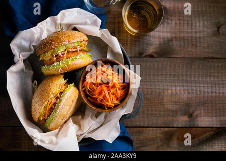 Vegan sweet potato chickpea burgers with avocado guacamole sauce and carrot slaw on wooden background top view with copy space for text.Vegetarian Stock Photo