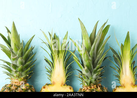 Top of pineapples on blue background, close up. Juicy fruit Stock Photo