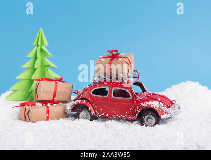 Winter imagine with toy car Volkswagen Beetle, presents and Christmas tree Stock Photo