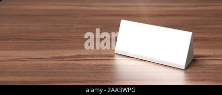 Reservation concept. Table tent blank, reserved card sign template against wood background. White paper cardboard, copy space, banner. 3d illustration Stock Photo