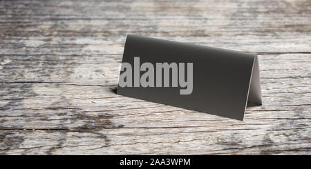 Reservation concept. Table tent blank, reserved card sign template against wood background. Metal aluminum silver color, copy space. 3d illustration Stock Photo