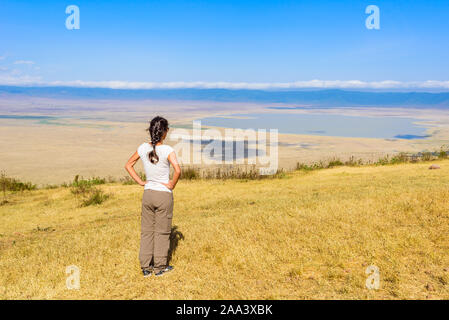 Tourist looks into the Ngorongoro crater National Park with the Lake Magadi. Safari Tours in Savannah of Africa. Beautiful landscape scenery in Tanzan