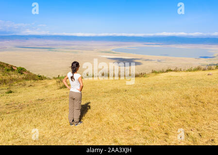 Tourist looks into the Ngorongoro crater National Park with the Lake Magadi. Safari Tours in Savannah of Africa. Beautiful landscape scenery in Tanzan