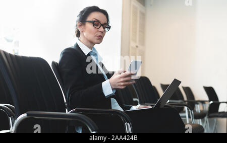 Businesswoman preparing for presentation, sitting in empty conference room Stock Photo