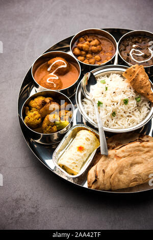 Indian vegetarian Food Thali or platter includes paneer butter masala, dal makhani / tarka, chole papad, kofta curry, gulab jamun, aloo-gobi sabji, ch Stock Photo