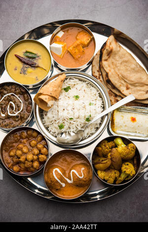 Indian vegetarian Food Thali or platter includes paneer butter masala, dal makhani / tarka, chole papad, kofta curry, gulab jamun, aloo-gobi sabji, ch Stock Photo