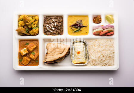 Indian vegaterian Food Thali or Parcel food-tray with compartments in which paneer, dal makhani / parka, aloo-gobi sabji, chapati and rice with Bengal Stock Photo