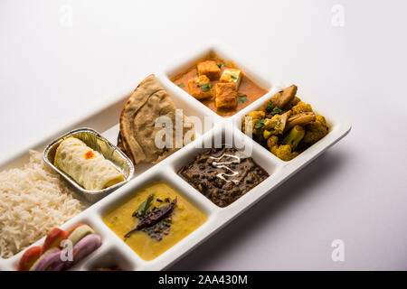 Indian vegaterian Food Thali or Parcel food-tray with compartments in which paneer, dal makhani / parka, aloo-gobi sabji, chapati and rice with Bengal Stock Photo