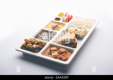 Indian vegaterian Food Thali or Parcel food-tray with compartments in which paneer, dal makhani / parka, aloo-gobi sabji, chapati and rice with Bengal Stock Photo