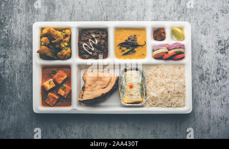 Indian vegaterian Food Thali or Parcel food-tray with compartments in which paneer, dal makhani / parka, aloo-gobi sabji, chapati and rice with Bengal Stock Photo