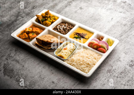 Indian vegaterian Food Thali or Parcel food-tray with compartments in which paneer, dal makhani / parka, aloo-gobi sabji, chapati and rice with Bengal Stock Photo