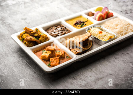 Indian vegaterian Food Thali or Parcel food-tray with compartments in which paneer, dal makhani / parka, aloo-gobi sabji, chapati and rice with Bengal Stock Photo