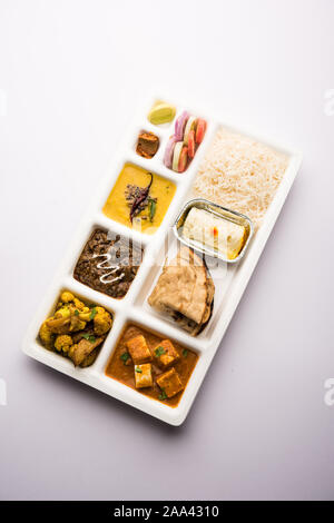 Indian vegaterian Food Thali or Parcel food-tray with compartments in which paneer, dal makhani / parka, aloo-gobi sabji, chapati and rice with Bengal Stock Photo