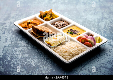 Indian vegaterian Food Thali or Parcel food-tray with compartments in which paneer, dal makhani / parka, aloo-gobi sabji, chapati and rice with Bengal Stock Photo