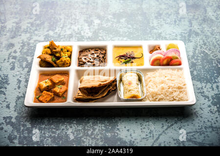 Indian vegaterian Food Thali or Parcel food-tray with compartments in which paneer, dal makhani / parka, aloo-gobi sabji, chapati and rice with Bengal Stock Photo