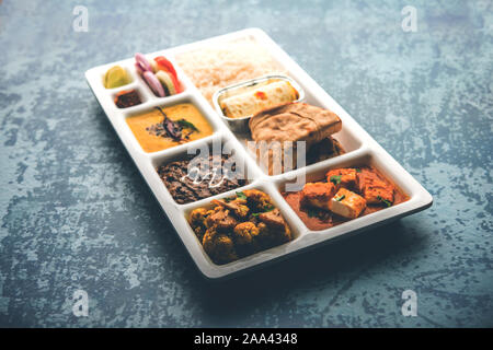 Indian vegaterian Food Thali or Parcel food-tray with compartments in which paneer, dal makhani / parka, aloo-gobi sabji, chapati and rice with Bengal Stock Photo