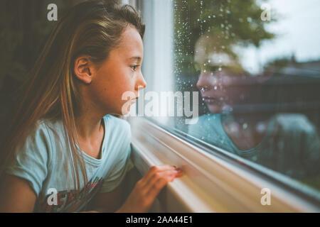 Girl looking through a train window, England, United Kingdom Stock Photo