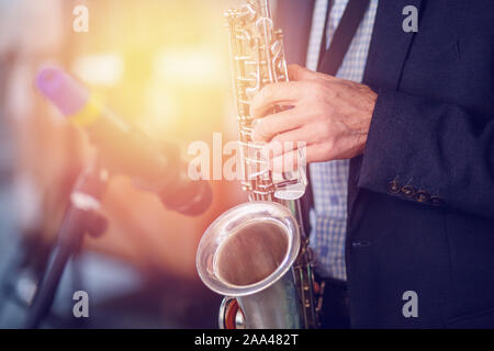 Jazz man musician playing saxophone with sun light. Stock Photo