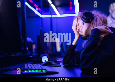 Streamer beautiful girl regrets losing professional gamer loser playing online games computer, neon color. Stock Photo