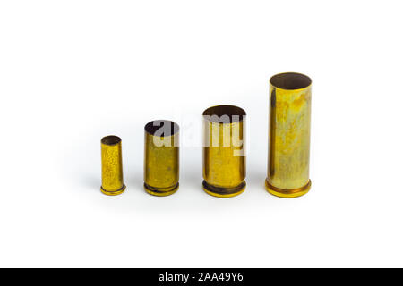 Comparison of sizes of different used bullet shells on a white isolated background with reflection from a tin table top. View of the different caliber Stock Photo