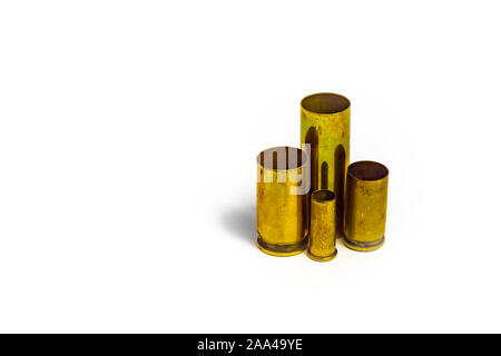 Comparison of sizes of different used bullet shells on a white isolated background with reflection from a tin table top. View of the different caliber Stock Photo